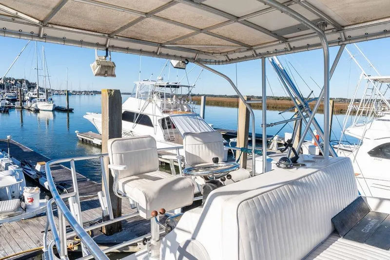 Slide: The Image of 2004 Luhrs 36 Convertible yacht docked at a marina, featuring a spacious helm. - 17