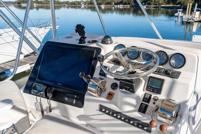 Slide: The Image of Control panel of a 2004 Luhrs 36 Convertible boat with steering wheel and navigation equipment. - 18