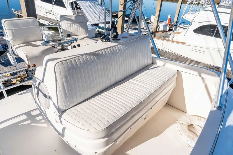 Slide: The Image of 2004 Luhrs 36 Convertible boat interior with white seating at marina. - 23