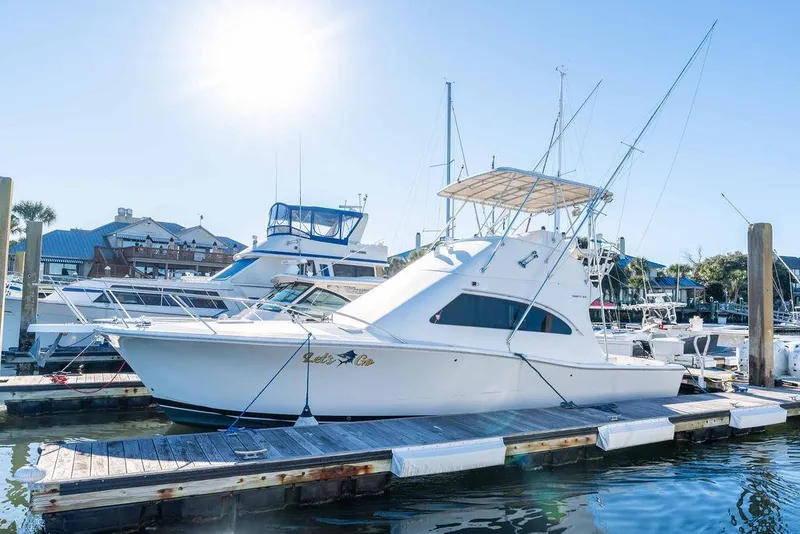 Slide: The Image of 2004 Luhrs 36 Convertible yacht docked at marina under clear blue sky. - 3