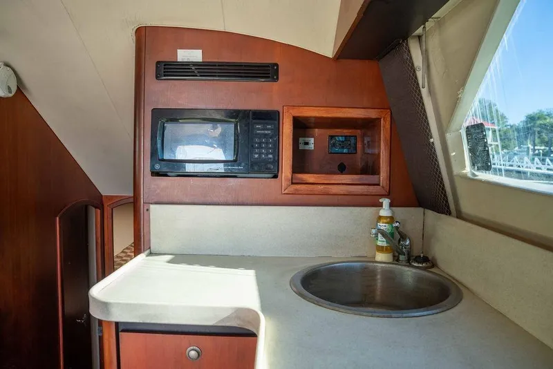 Slide: The Image of 2004 Luhrs 36 Convertible yacht kitchen with microwave, sink, and countertop. - 33