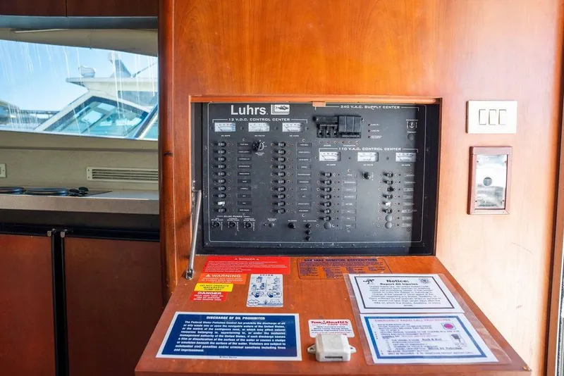 Slide: The Image of Control panel of a 2004 Luhrs 36 Convertible boat, featuring switches and safety notices. - 34