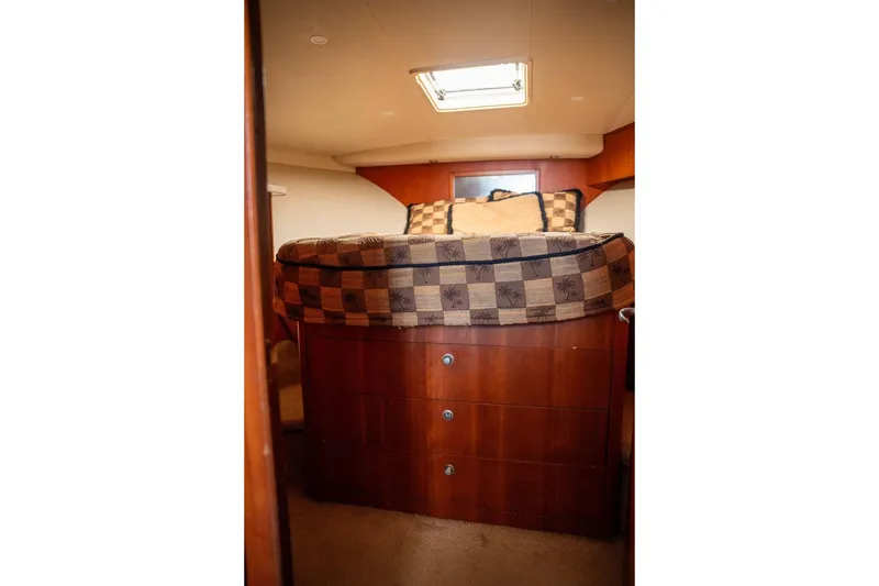 Slide: The Image of 2004 Luhrs 36 Convertible cabin interior with bed and wooden storage drawers. - 42