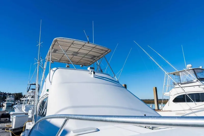 Slide: The Image of 2004 Luhrs 36 Convertible yacht docked under clear blue sky. - 7
