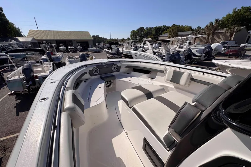 Slide: The Image of 2020 Tidewater 320 CC Adventure boat interior at a marina, showcasing seating and speakers. - 13