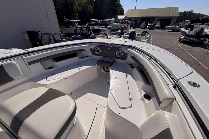 Slide: The Image of 2020 Tidewater 320 CC Adventure boat interior with seating and speakers in a marina setting. - 14