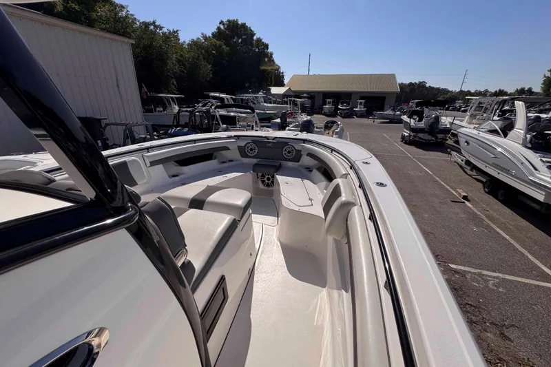 Slide: The Image of 2020 Tidewater 320 CC Adventure boat in a marina, showcasing spacious seating and sleek design. - 16