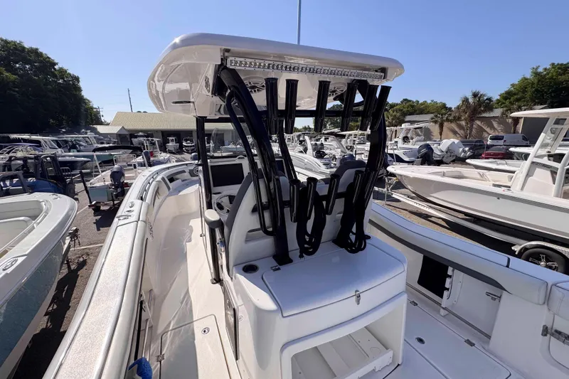 Slide: The Image of 2020 Tidewater 320 CC Adventure boat in marina, showcasing helm and seating area. - 19