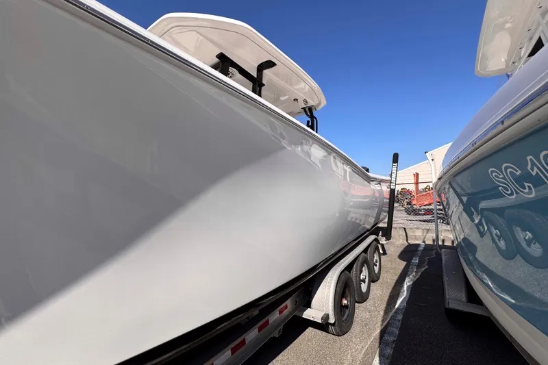 Slide: The Image of 2020 Tidewater 320 CC Adventure boat on trailer under clear blue sky. - 9