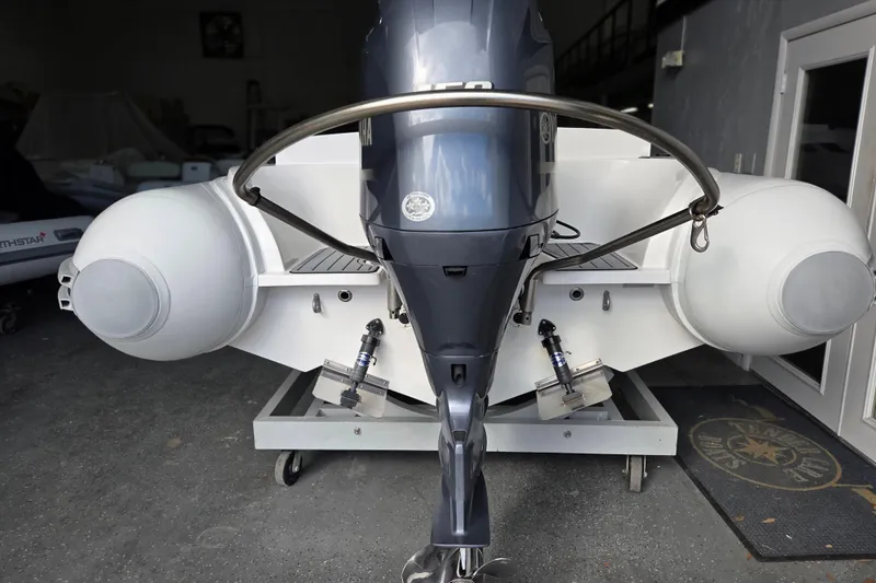 Slide: The Image of Novurania Como 18 boat, 2021 model, with outboard motor in a garage setting. - 5