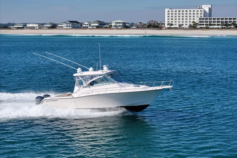 Slide: The Image of 2008 Grady-White Express 360 cruising on blue ocean near sandy beach and buildings. - 13
