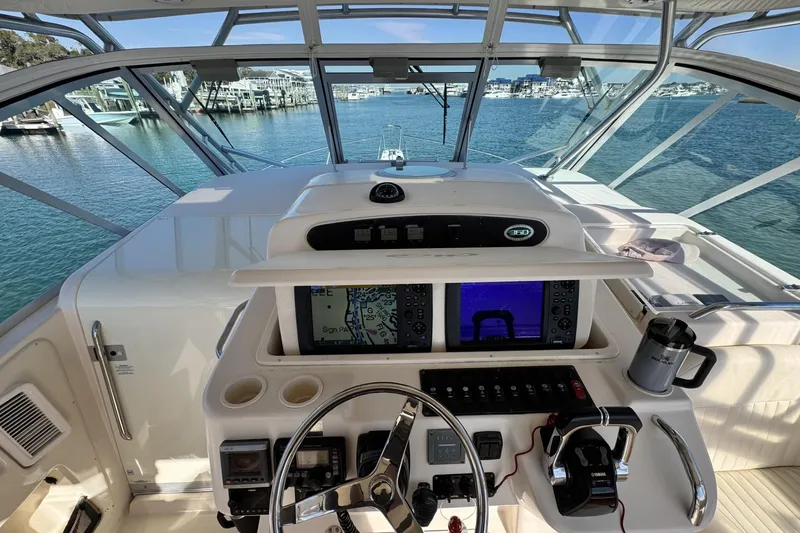 Slide: The Image of 2008 Grady-White Express 360 helm with navigation screens, steering wheel, and ocean view. - 45