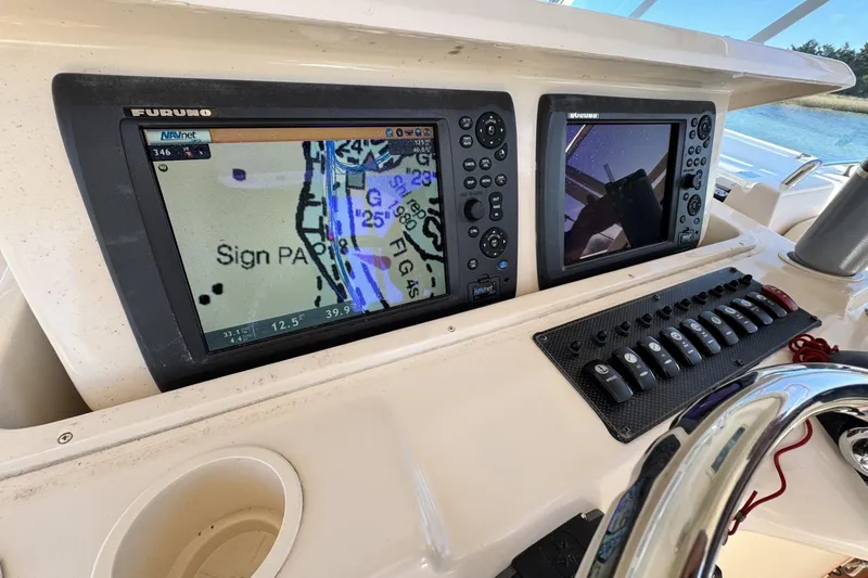 Slide: The Image of 2008 Grady-White Express 360 boat dashboard with navigation screens and control panel. - 46