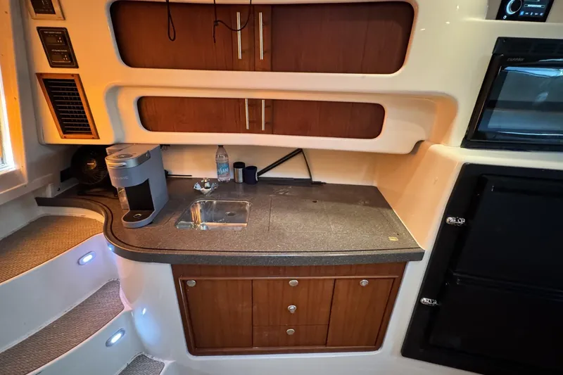 Slide: The Image of 2008 Grady-White Express 360 interior with kitchenette, featuring sink, cabinets, and appliances. - 62