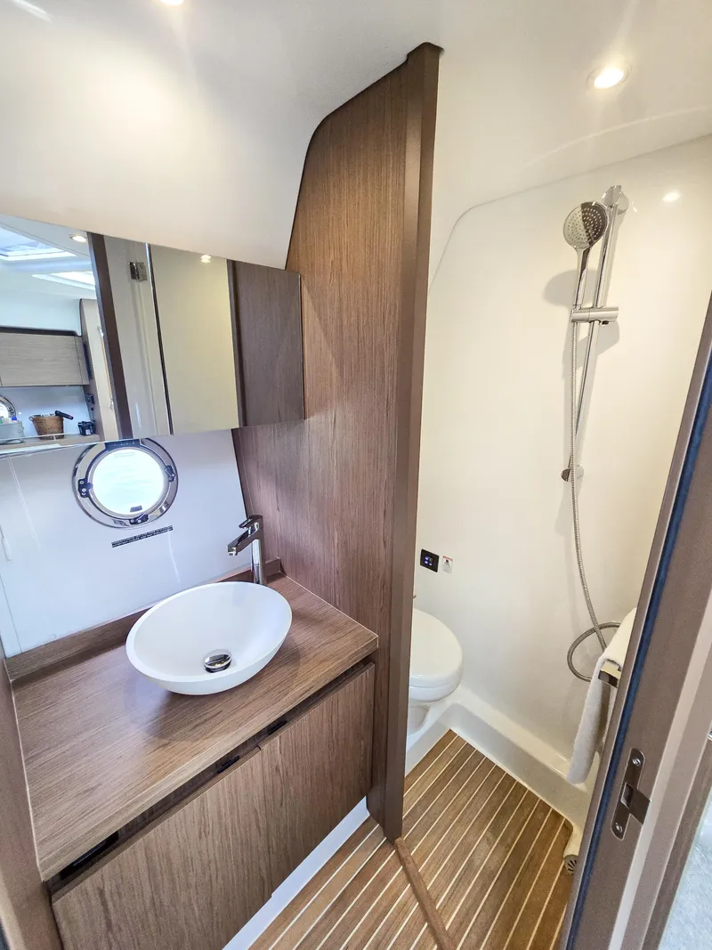 Slide: The Image of Luxurious bathroom in 2019 Beneteau Gran Turismo 40 yacht with modern fixtures and wood accents. - 13