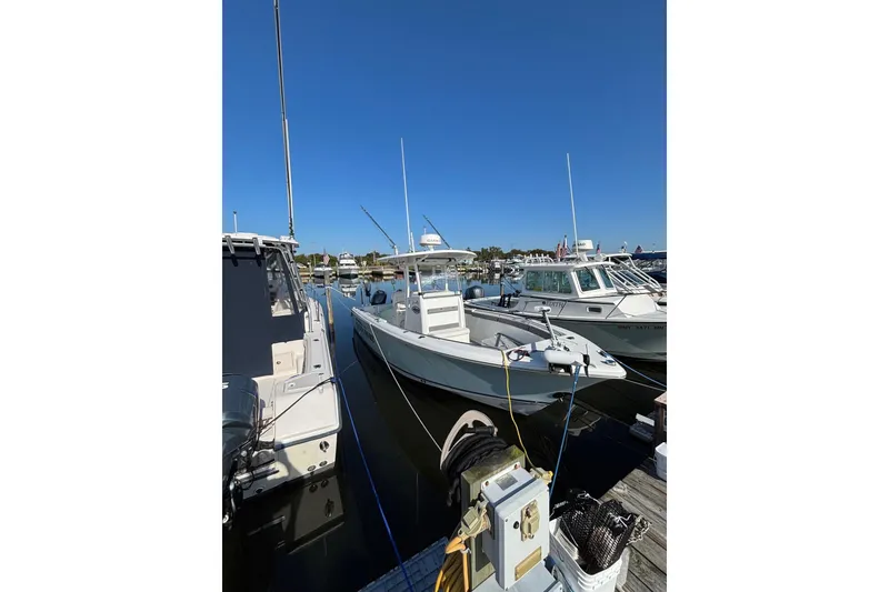 The Image of 2013 Sea Hunt Gamefish 25 boat docked, featuring Garmin equipment and Minn Kota trolling motor. - 0