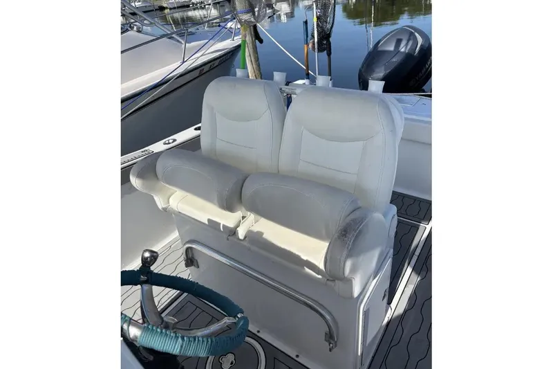 Slide: The Image of 2013 Sea Hunt Gamefish 25 boat with dual white captain's chairs and steering wheel. - 10