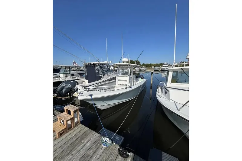Slide: The Image of 2013 Sea Hunt Gamefish 25 docked at marina under clear blue sky. - 11