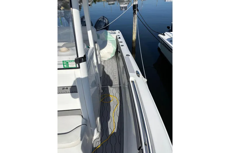 Slide: The Image of 2013 Sea Hunt Gamefish 25 boat docked, showing deck and railing details. - 7