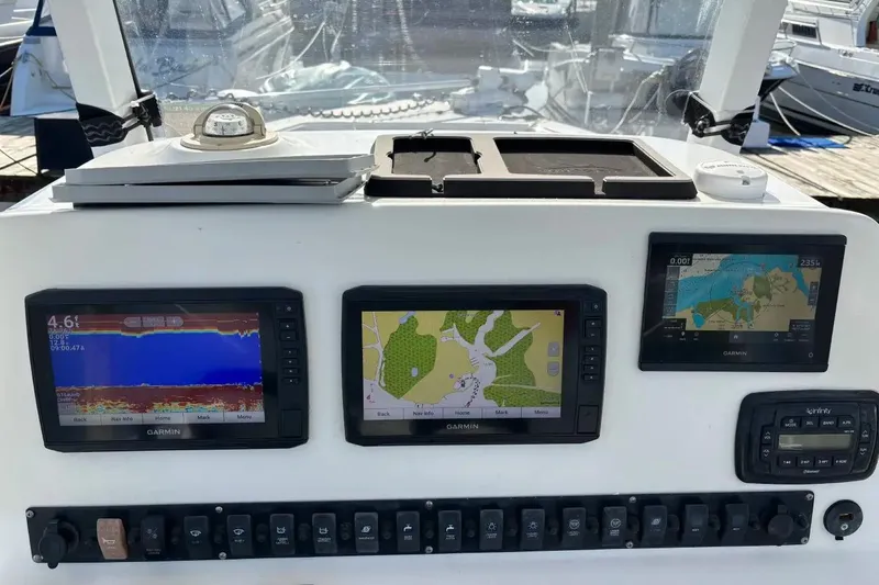 Slide: The Image of 2013 Sea Hunt Gamefish 25 dashboard with Garmin navigation displays and control panel. - 9