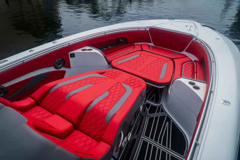 Slide: The Image of 2024 MTI V42 boat with luxurious red and gray seating, docked on water. - 14