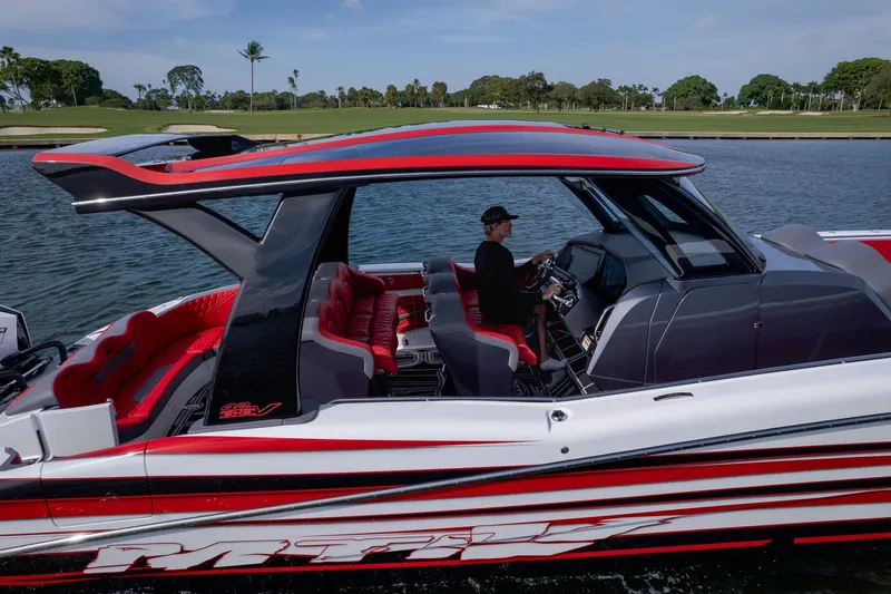 Slide: The Image of 2024 MTI V42 boat with sleek design, red and black accents, cruising on water. - 4