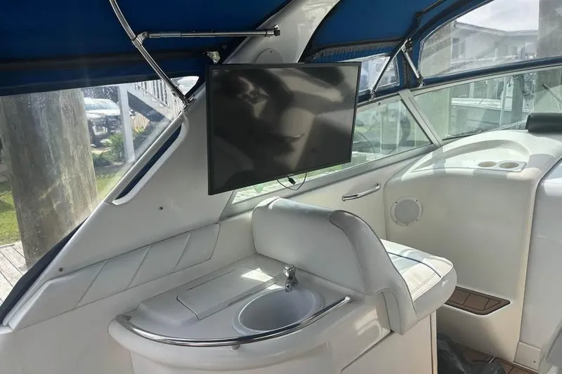 Slide: The Image of Interior of 1996 Sea Ray 330 Sundancer with TV and sink, featuring blue canopy. - 3