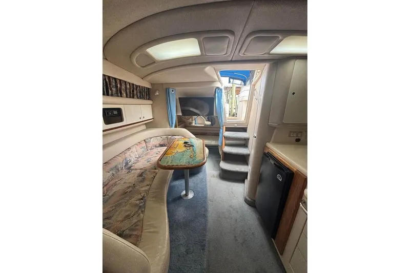Slide: The Image of Interior of 1996 Sea Ray 330 Sundancer yacht with seating, table, and kitchenette. - 4