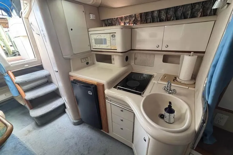 Slide: The Image of Interior of 1996 Sea Ray 330 Sundancer boat kitchen with appliances and storage. - 7