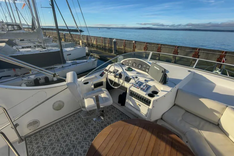 Slide: The Image of 2002 Bayliner 3988 Command Bridge Motoryacht helm with ocean view and seating area. - 12