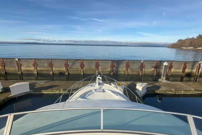 Slide: The Image of Bayliner 3988 Command Bridge Motoryacht docked at a serene waterfront, 2002 model. - 14