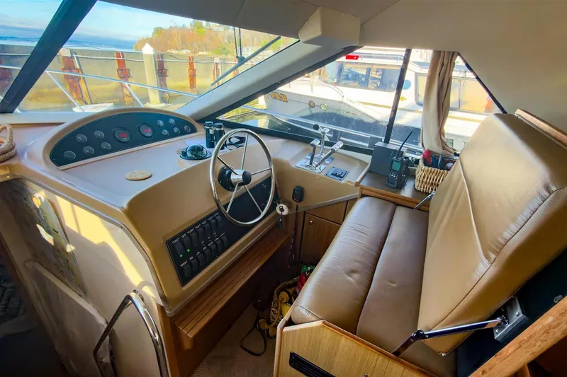Slide: The Image of 2002 Bayliner 3988 Command Bridge Motoryacht helm with steering wheel and control panel. - 24