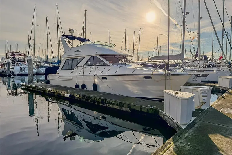 Slide: The Image of 2002 Bayliner 3988 Command Bridge Motoryacht docked at marina under sunny sky. - 3