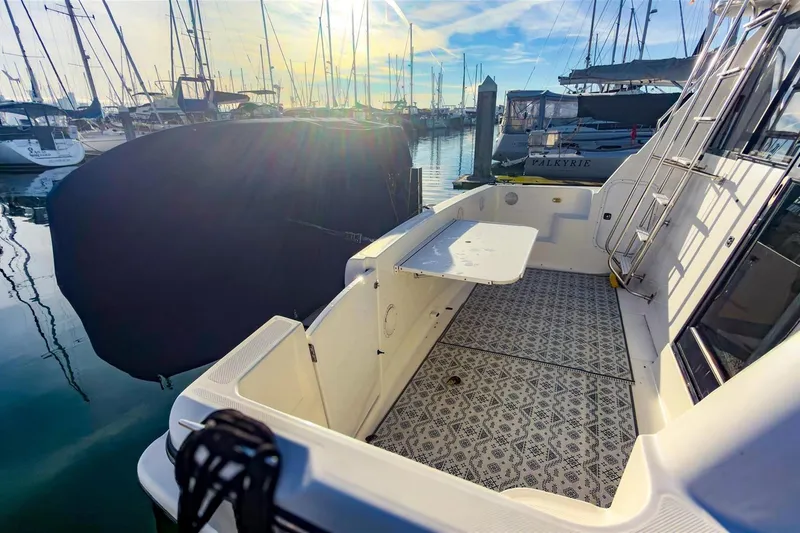 Slide: The Image of 2002 Bayliner 3988 Command Bridge Motoryacht docked, featuring spacious deck and patterned flooring. - 5