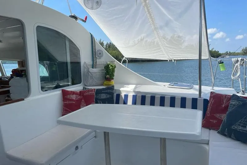 Slide: The Image of Cozy seating area on 2006 Lagoon 410-S2 catamaran with nautical-themed cushions. - 1