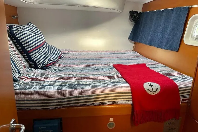 Slide: The Image of Cozy cabin interior of 2006 Lagoon 410-S2 with striped bedding and nautical decor. - 14