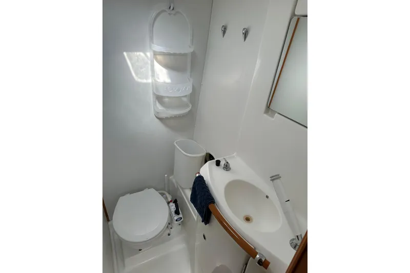 Slide: The Image of Compact bathroom in 2006 Lagoon 410-S2 yacht with sink, toilet, and storage. - 19