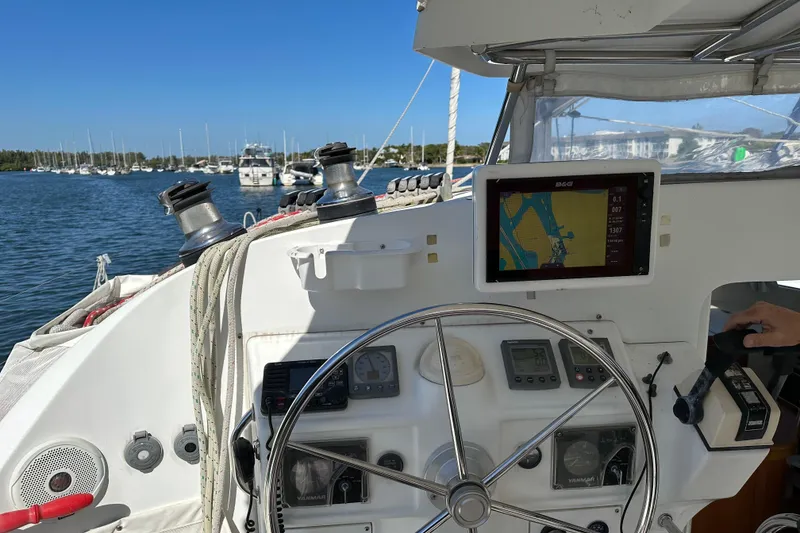 Slide: The Image of Steering area of a 2006 Lagoon 410-S2 catamaran with navigation equipment and marina view. - 22