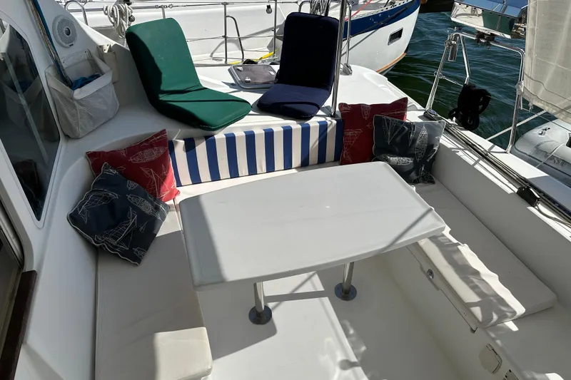 Slide: The Image of Cozy seating area on 2006 Lagoon 410-S2 catamaran with cushions and table. - 23