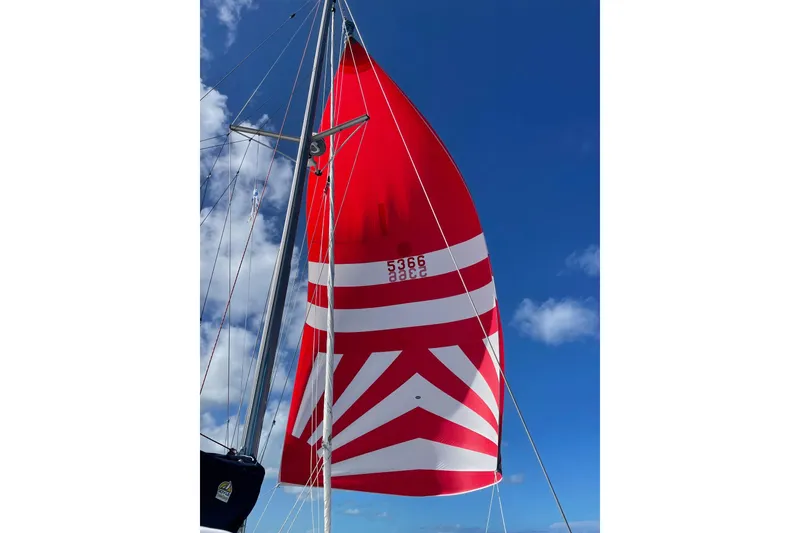 Slide: The Image of Red and white sail on 2006 Lagoon 410-S2 catamaran against blue sky. - 32