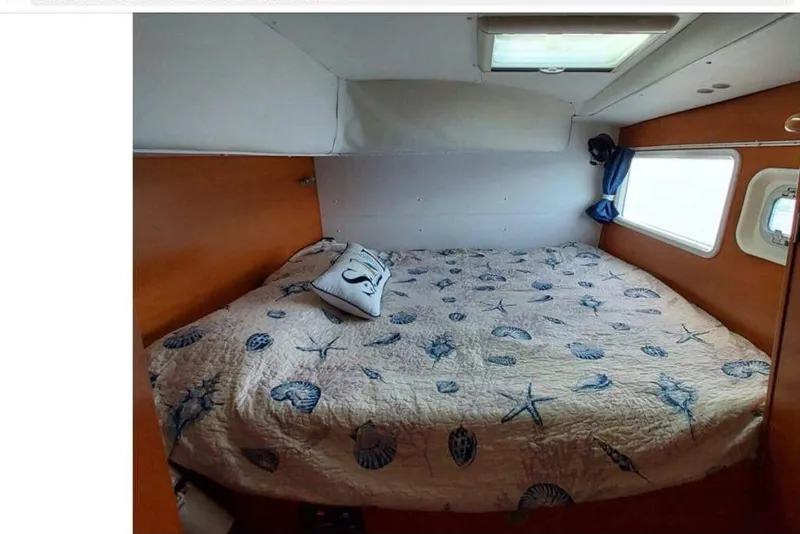 Slide: The Image of Cozy cabin bedroom in 2006 Lagoon 410-S2 catamaran with nautical-themed bedding. - 13
