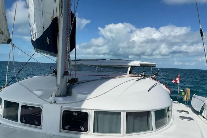 Slide: The Image of 2006 Lagoon 410-S2 catamaran sailing on open sea under clear blue sky. - 24