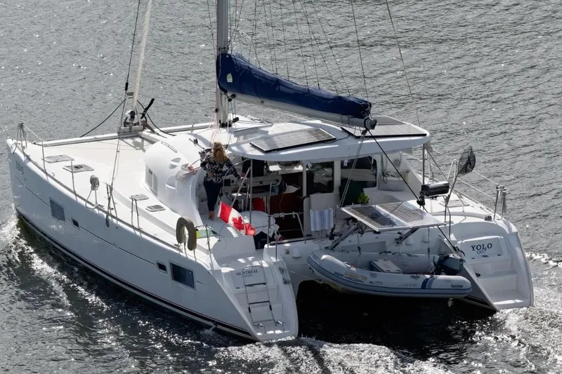 Slide: The Image of 2006 Lagoon 410-S2 catamaran sailing with Canadian flag on water. - 42