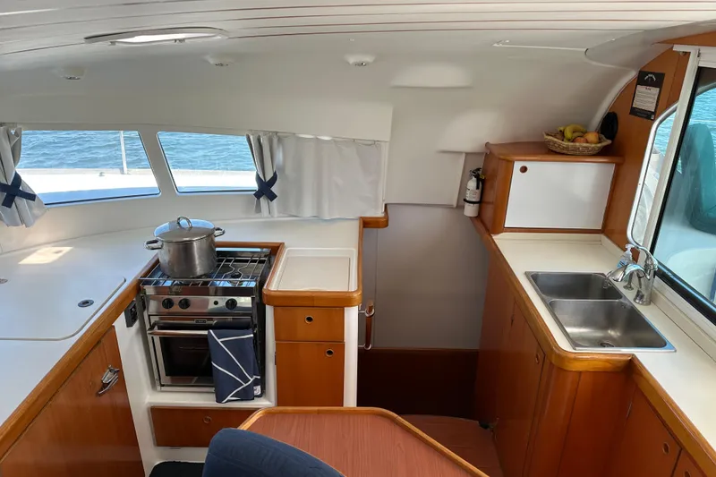 Slide: The Image of Interior of 2006 Lagoon 410-S2 yacht kitchen with stove, sink, and wooden cabinetry. - 5