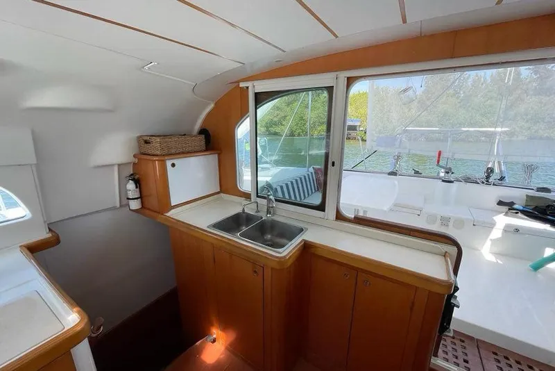 Slide: The Image of Interior of 2006 Lagoon 410-S2 catamaran with wooden cabinetry and a stainless steel sink. - 6