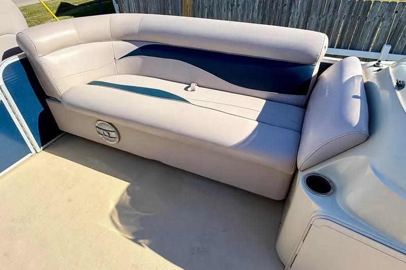 Slide: The Image of 2015 Sweetwater 2286 BF boat interior with beige seating and cup holder. - 13