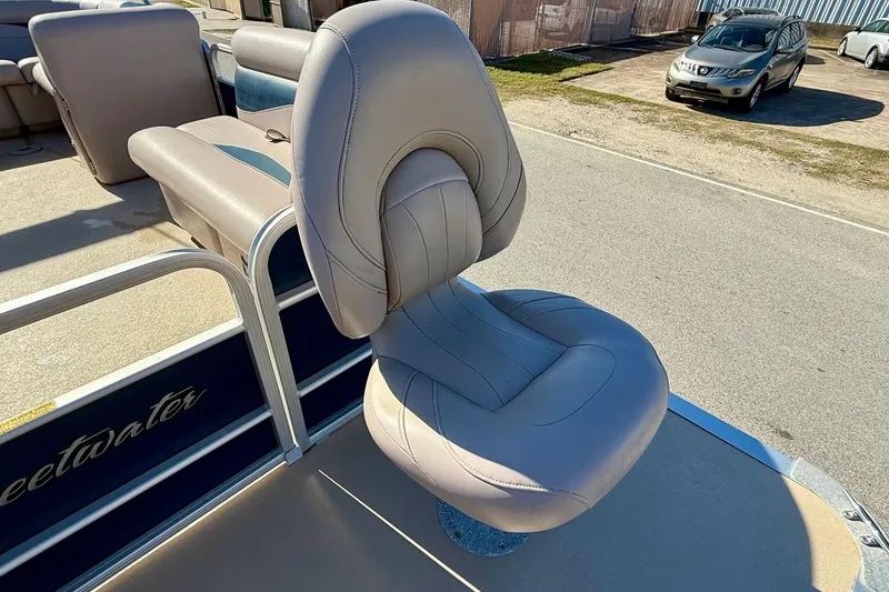 Slide: The Image of 2015 Sweetwater 2286 BF boat with beige captain's chair and visible seating area. - 15