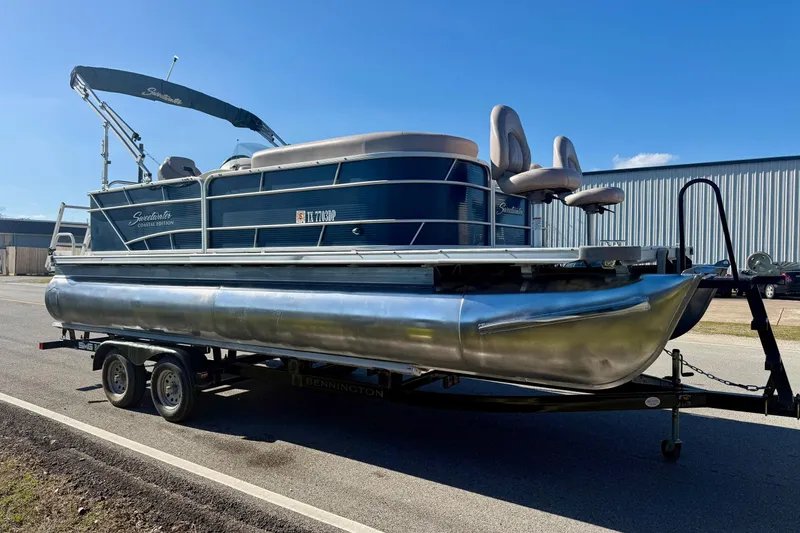 Slide: The Image of 2015 Sweetwater 2286 BF pontoon boat on trailer, parked outdoors under clear blue sky. - 5