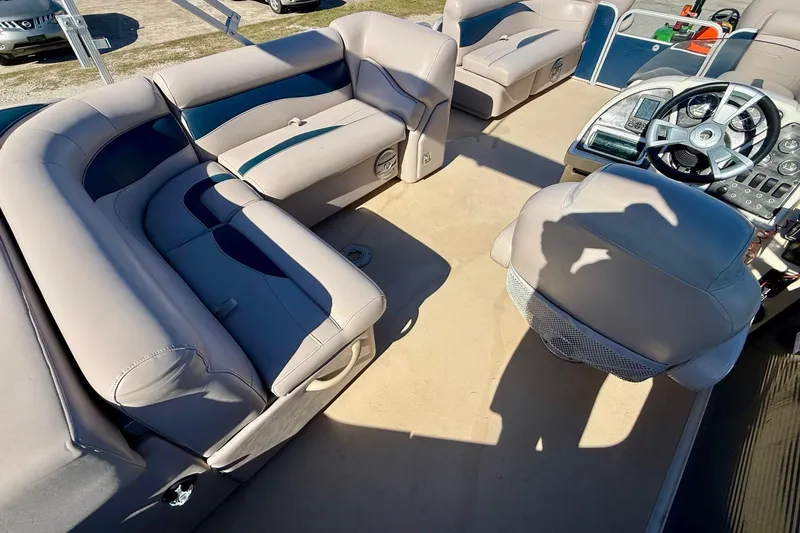 Slide: The Image of Interior of a 2015 Sweetwater 2286 BF boat with beige seating and steering console. - 8