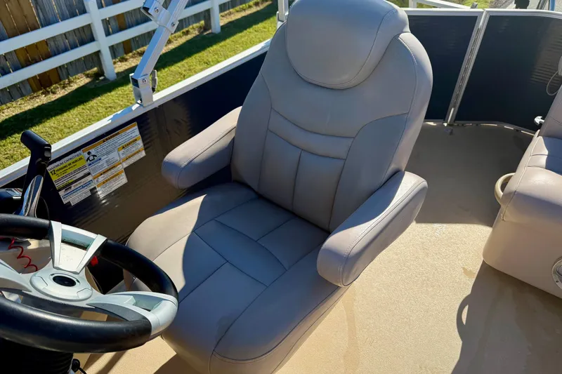 Slide: The Image of Captain's chair on 2015 Sweetwater 2286 BF boat, featuring comfortable seating and steering wheel. - 9